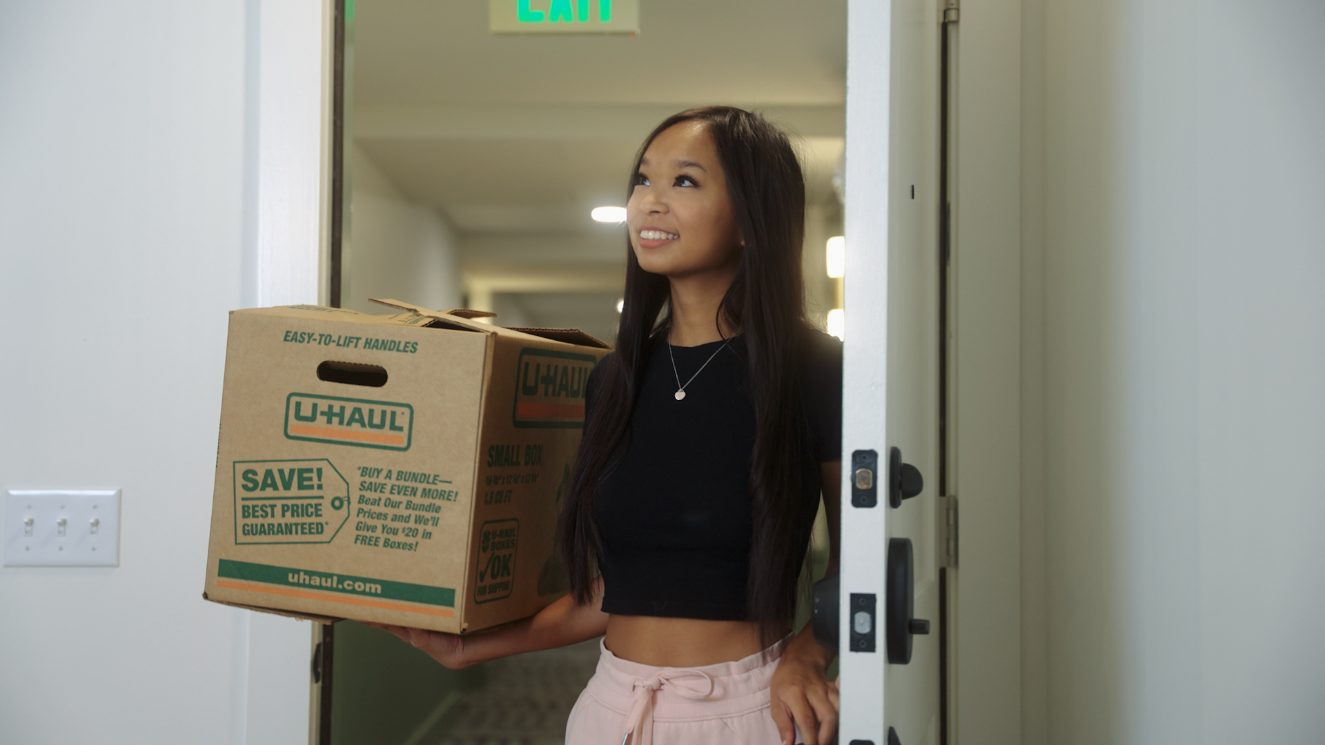 Girl moving into apartment in Gainesville holding moving box.