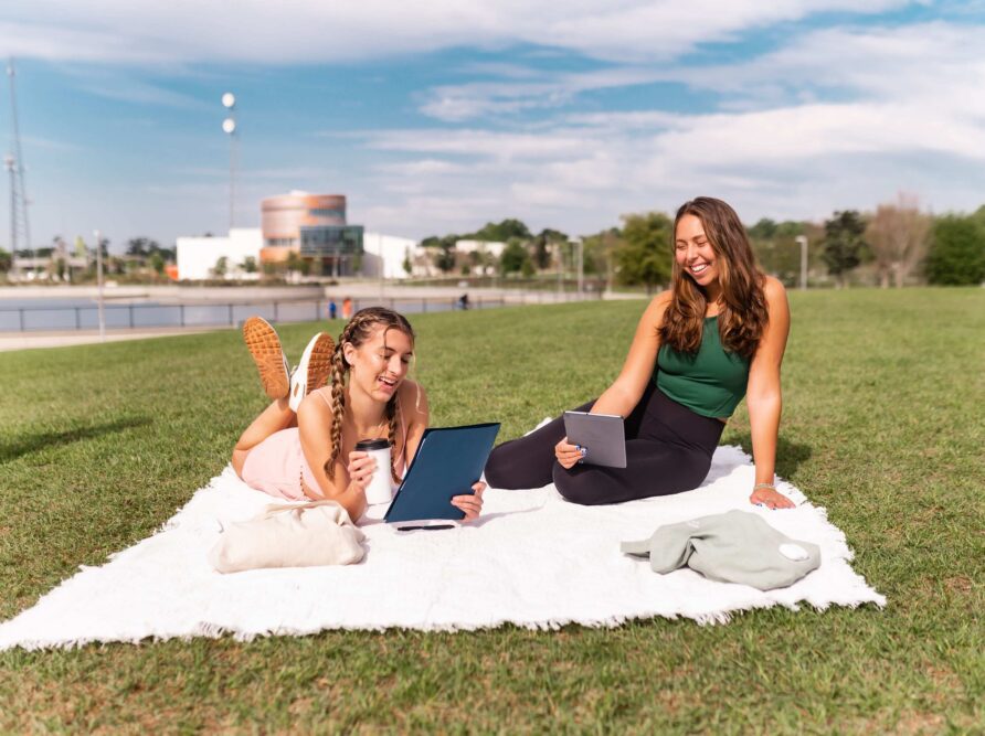 Two girls studying on a picnic blanket in Depot Park