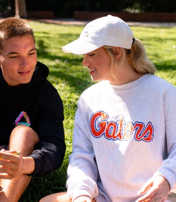 two UF students look at a notebook while studying together on the plaza of the americas at the university of florida in gainesville