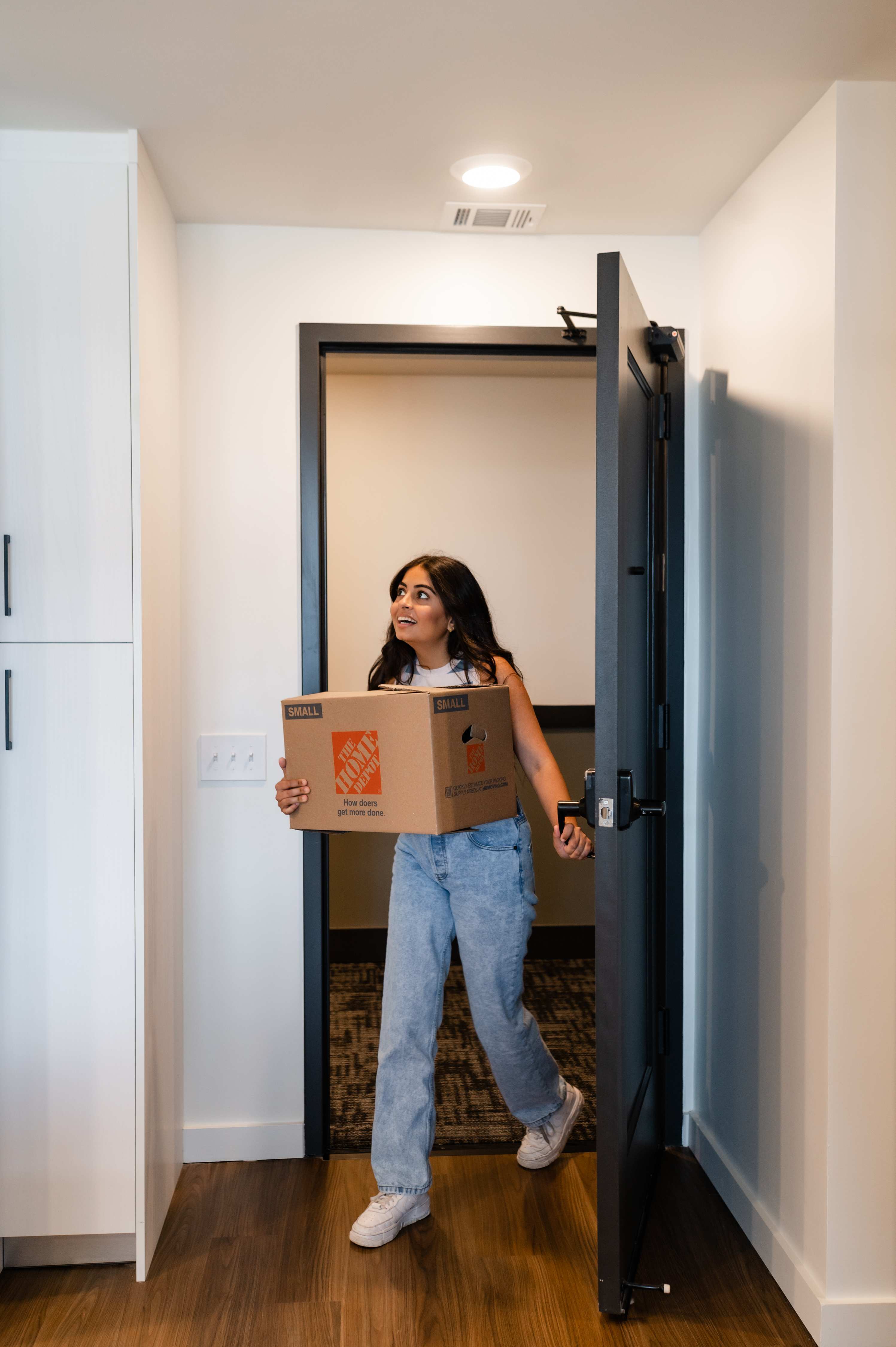 Girl bringing a box into her apartment